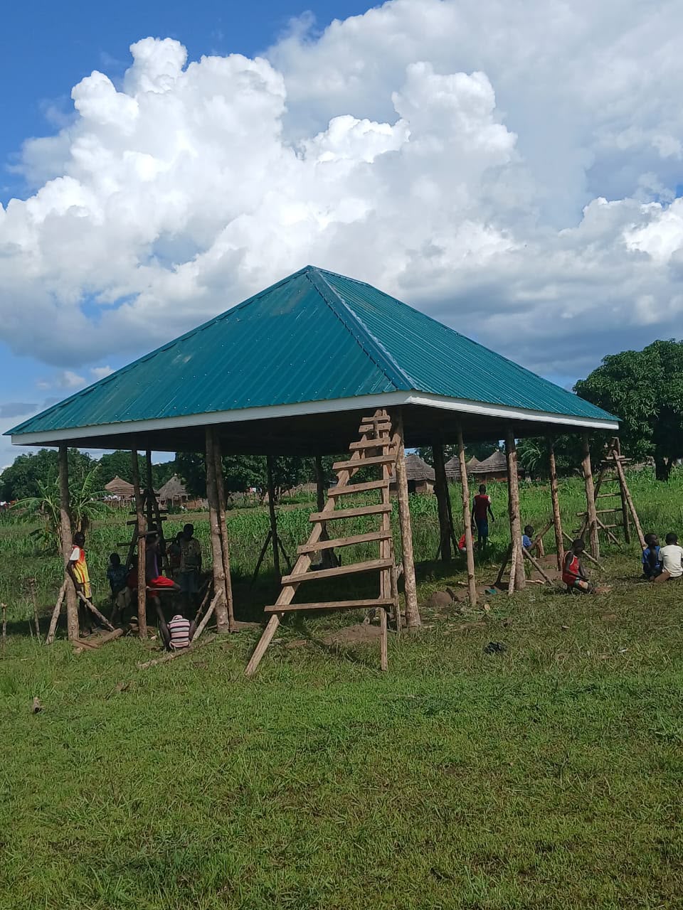 A completed classroom unit with its green pyramid roof on the Golden Mind Academy site in Ayilo.